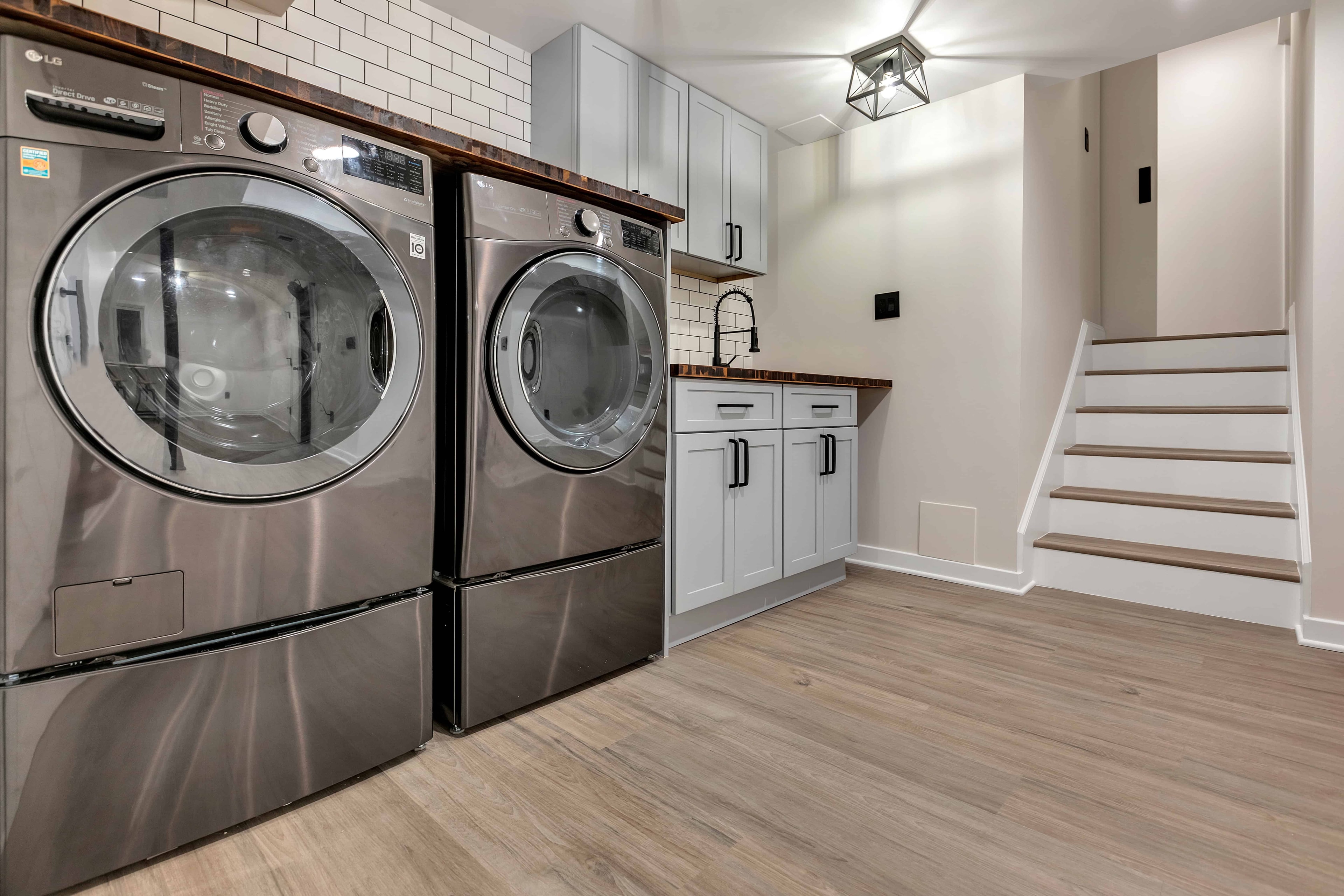 Laundry room renovation Wheaton MD — LG washer dryer pair, butcher block counters, white subway tile, sustainable design-build