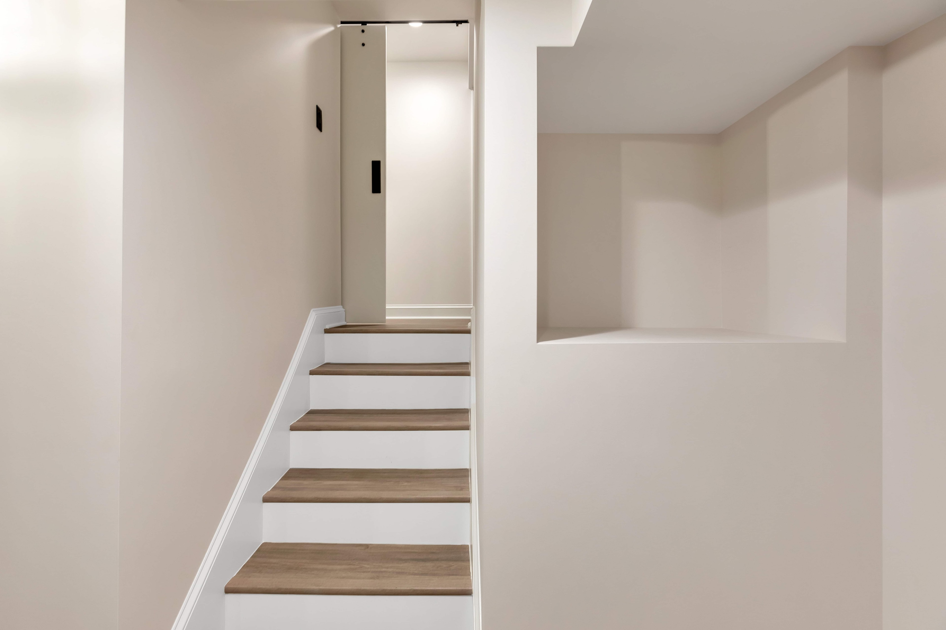 Finished basement staircase Maryland — warm wood treads, white risers, recessed LED lighting, eco-friendly basement remodel by Alleco Center
