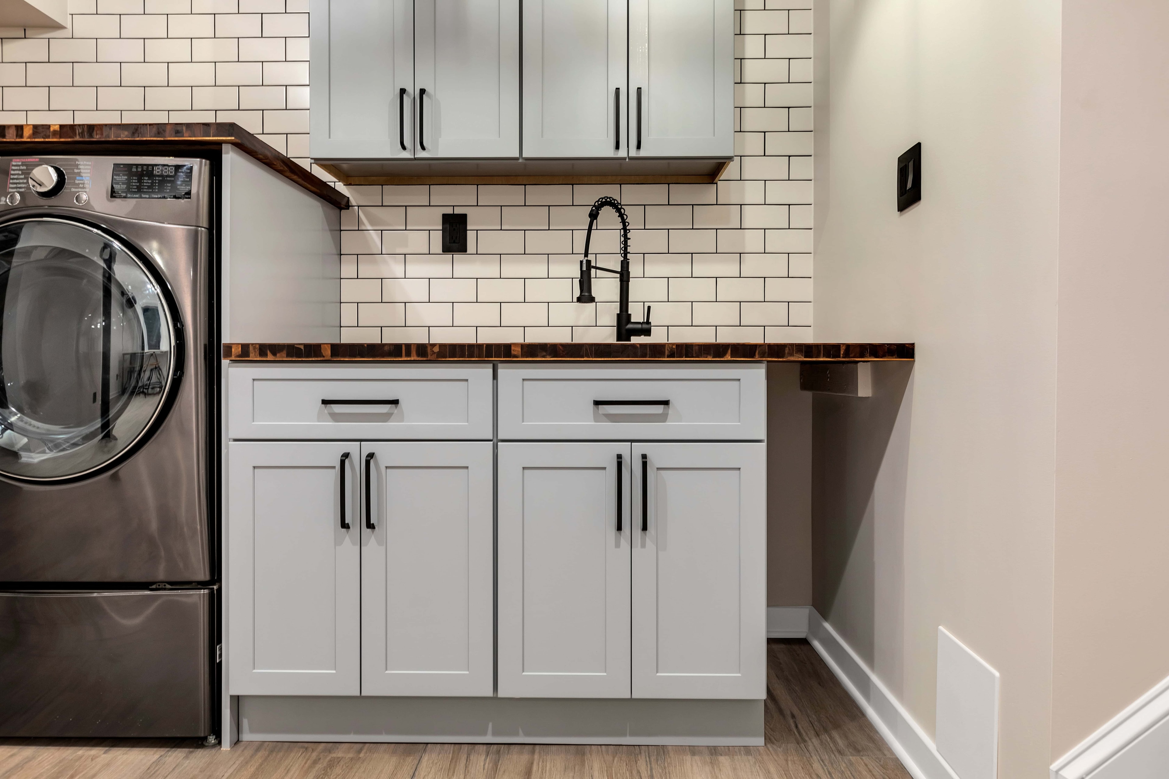 Laundry room with staircase Maryland — LG washer dryer, gray shaker cabinets, butcher block countertop, sustainable renovation by Alleco Center