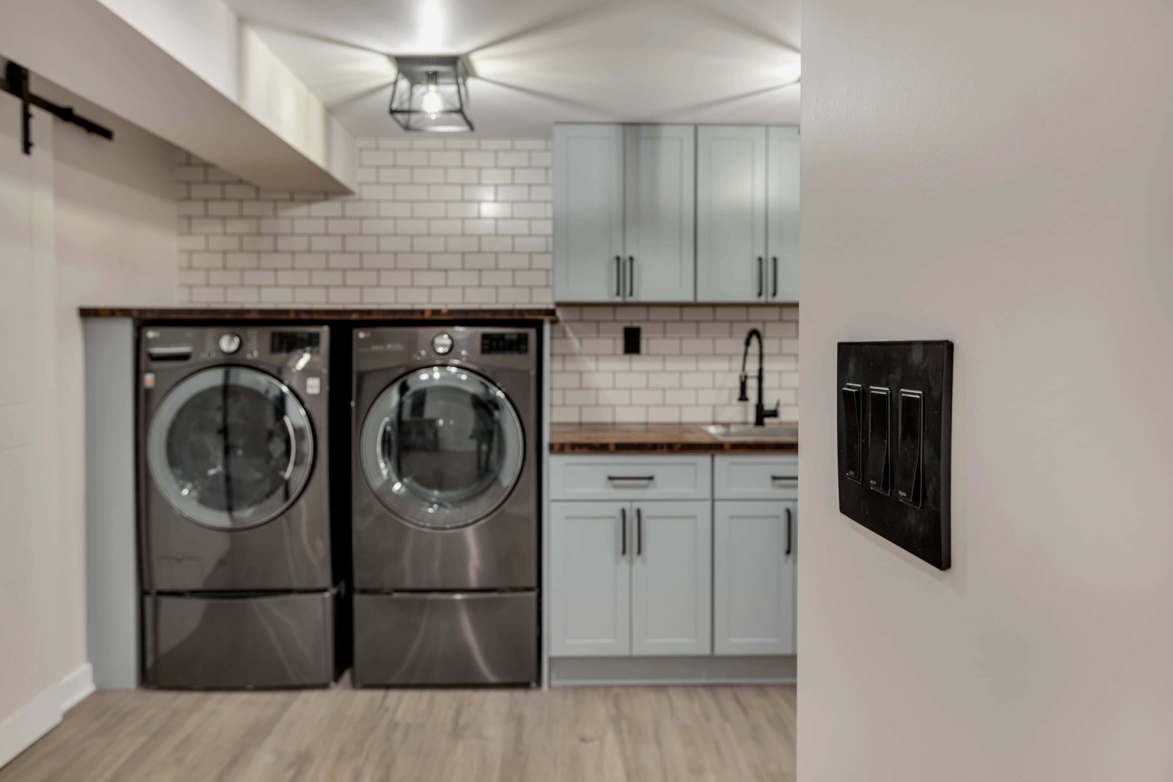 Walnut butcher block countertop detail — matte black coil faucet, undermount sink, subway tile, sustainable kitchen materials Maryland