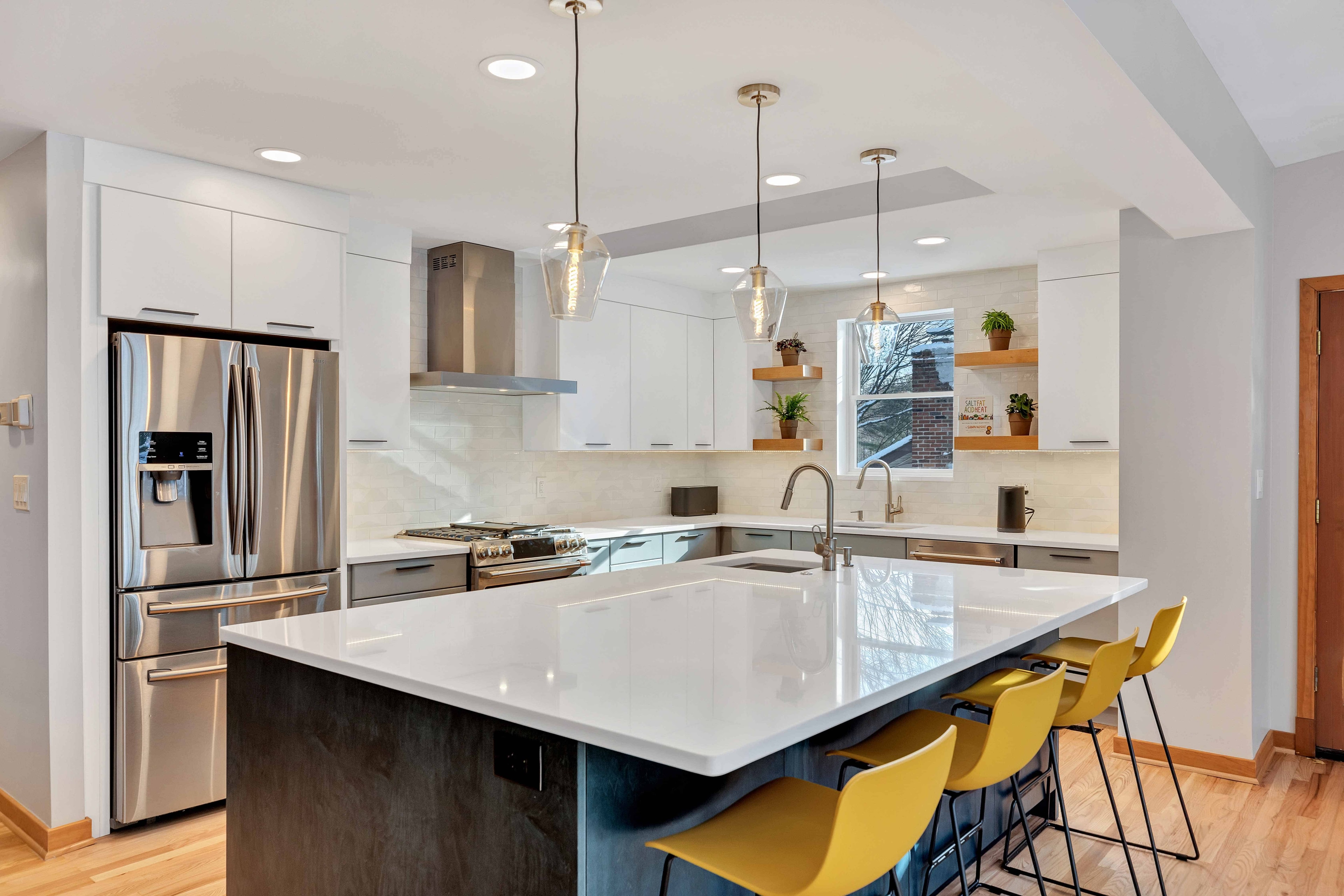 Kitchen renovation wide view Maryland — stainless refrigerator, gray island, pendant lights, LVP flooring, eco-friendly remodel