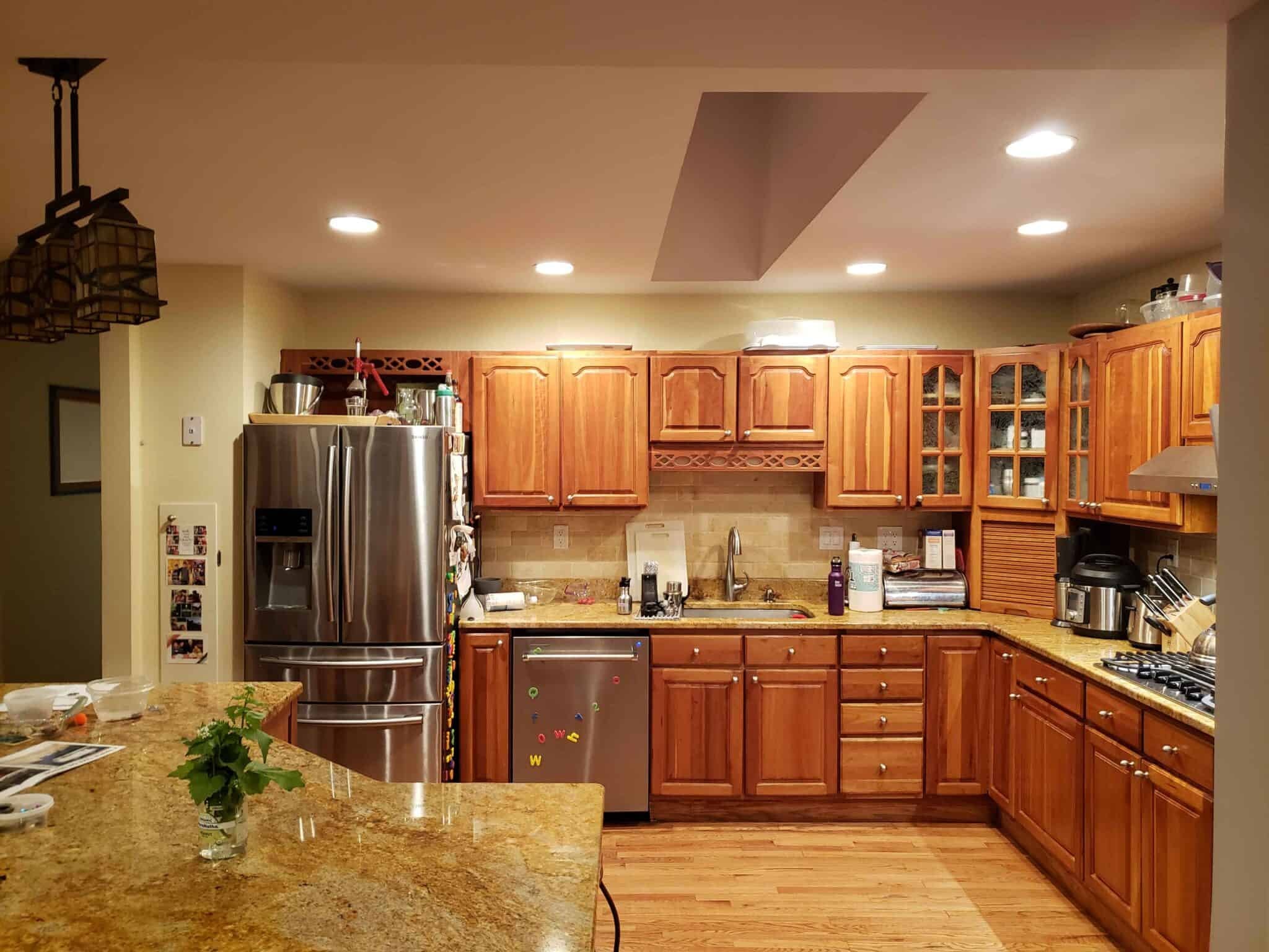 Kitchen before renovation close-up Maryland — warm wood cabinetry, granite countertops, before eco-friendly remodel by Alleco Center